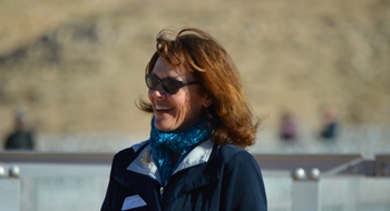 Astronomer Mary Lara outdoors on a sunny day, with blurred people in the background.